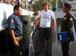 Cambodian military police escort Sergei Polonsky (centre) from a boat at Sihanoukville on Sunday.